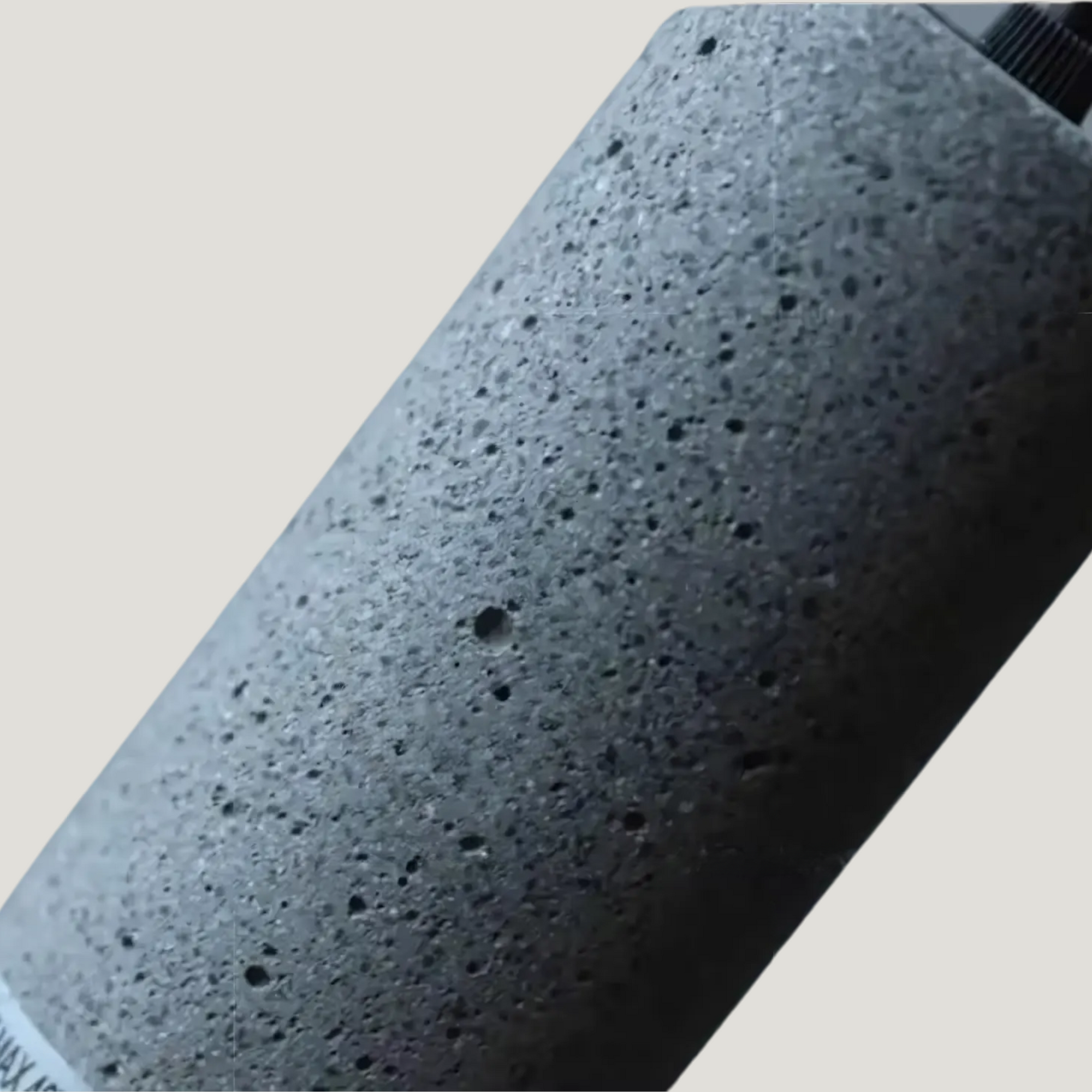 Détails rapprochés de la Suspension Telaire montrant sa structure en grille perforée noire et béton.